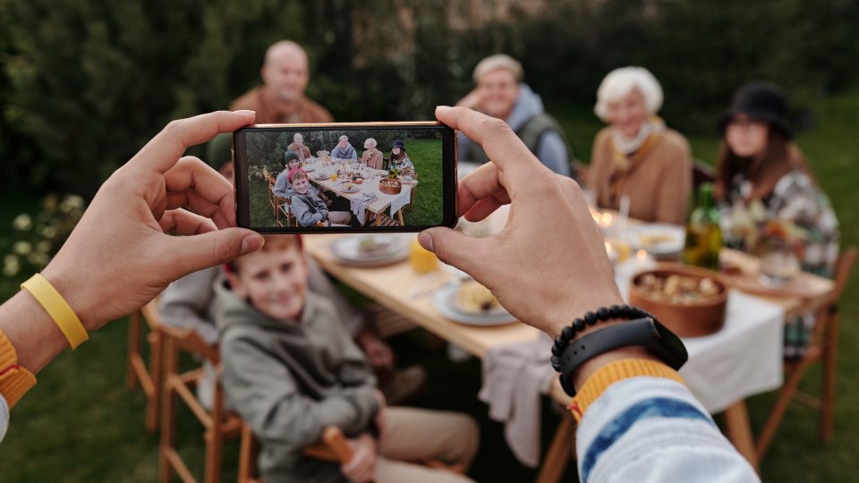 Foto einer Familie, die mit einem Smartphone fotografiert wird