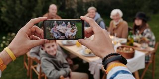 Foto einer Familie, die mit einem Smartphone fotografiert wird