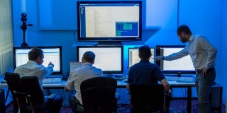 Vier Menschen vor Bildschirmen im Cybercrime-Kompetenzzentrum