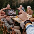 Foto einer Familie, die mit einem Smartphone fotografiert wird