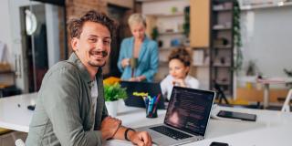 Mann vor einem Laptop im Büro